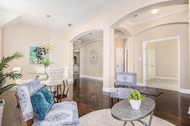 living room with crown molding, dark wood-type flooring, and a notable chandelier