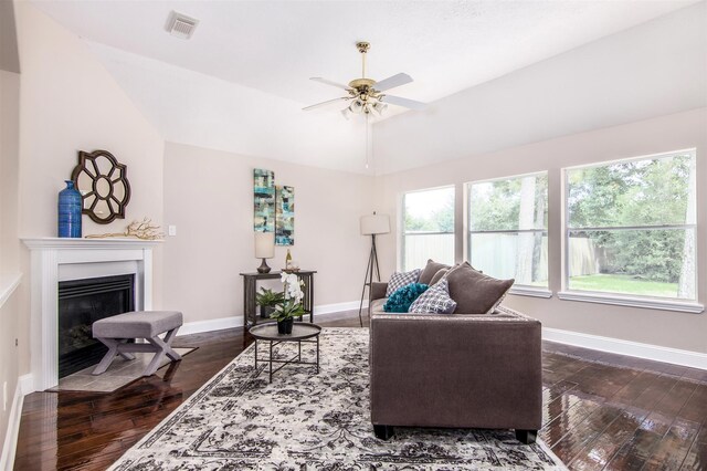 living room with lofted ceiling, ceiling fan, and dark wood-type flooring