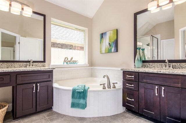 bathroom with separate shower and tub, vaulted ceiling, vanity, and tile patterned floors