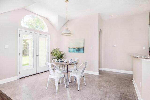 tiled dining area with vaulted ceiling and french doors