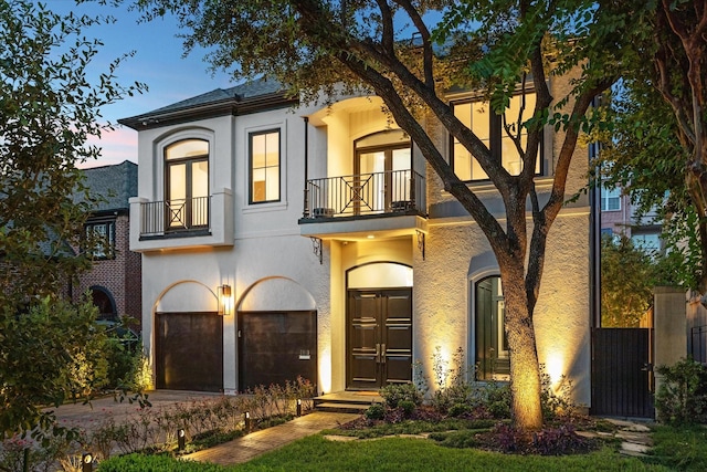 view of front of home featuring a garage and a balcony