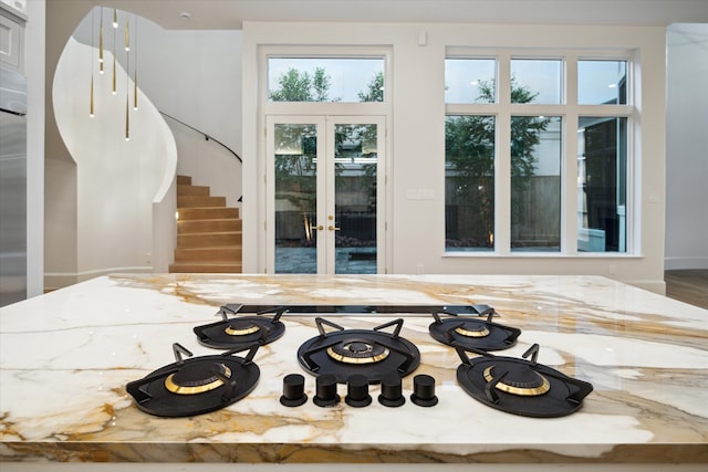 kitchen featuring light stone counters, white gas stovetop, and french doors