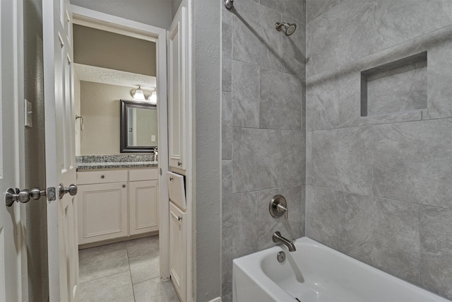 bathroom with tile patterned floors, vanity, and tiled shower / bath combo