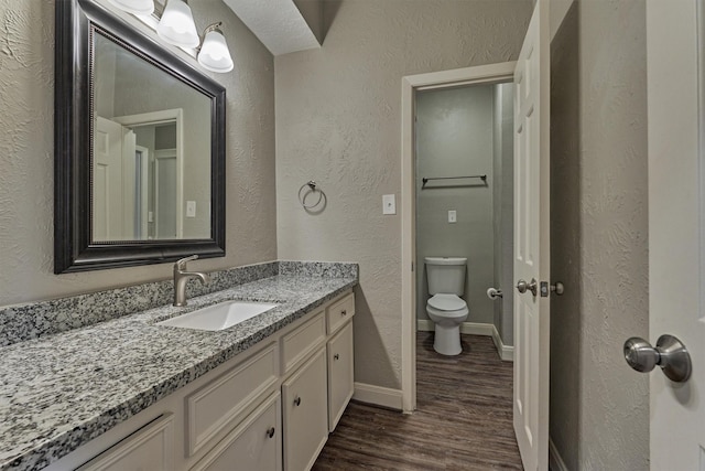 bathroom with hardwood / wood-style flooring, vanity, and toilet