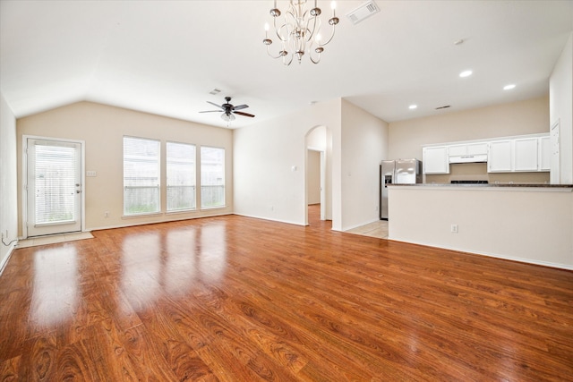 unfurnished living room with light wood-type flooring, ceiling fan with notable chandelier, and vaulted ceiling