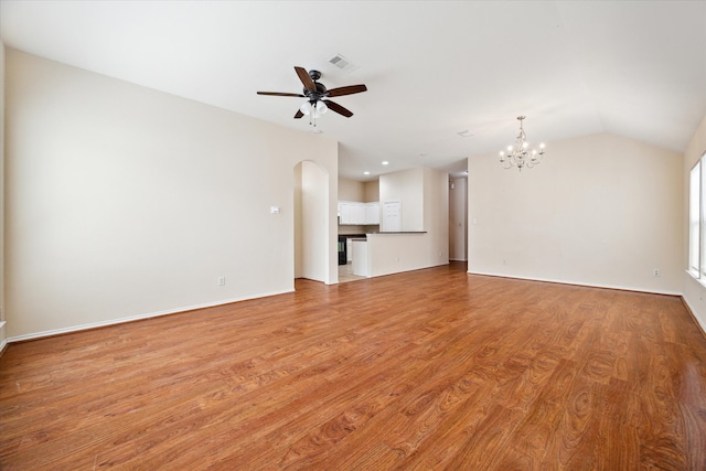 unfurnished living room with lofted ceiling, ceiling fan with notable chandelier, and light hardwood / wood-style floors