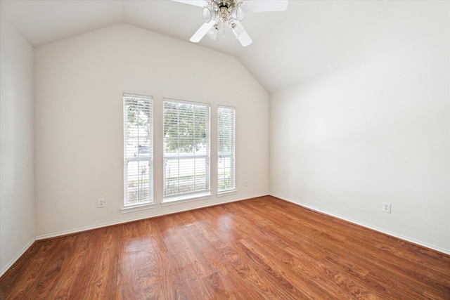 empty room featuring vaulted ceiling, hardwood / wood-style flooring, and ceiling fan