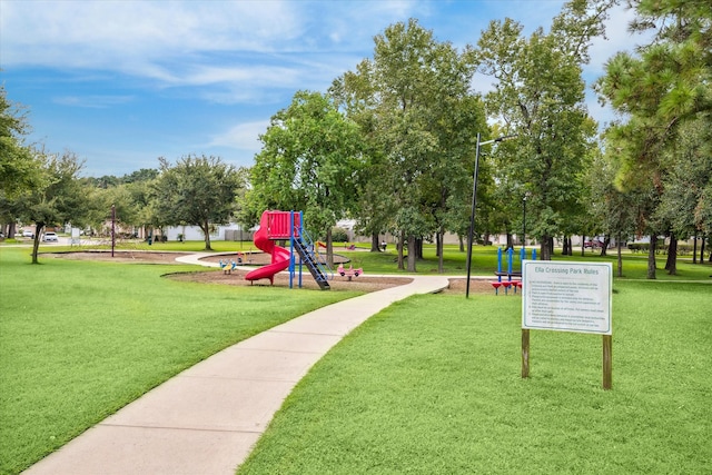 view of property's community with a playground and a yard