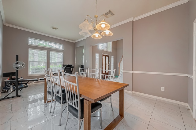 dining room with ornamental molding and a chandelier