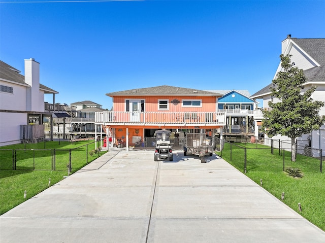 rear view of property with a balcony and a lawn