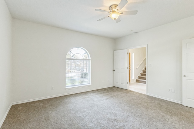 carpeted empty room featuring ceiling fan