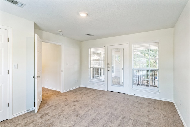 carpeted spare room with a textured ceiling