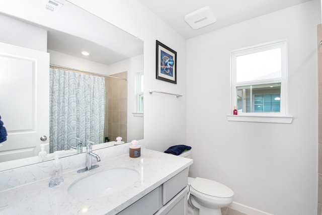 bathroom featuring curtained shower, vanity, and toilet