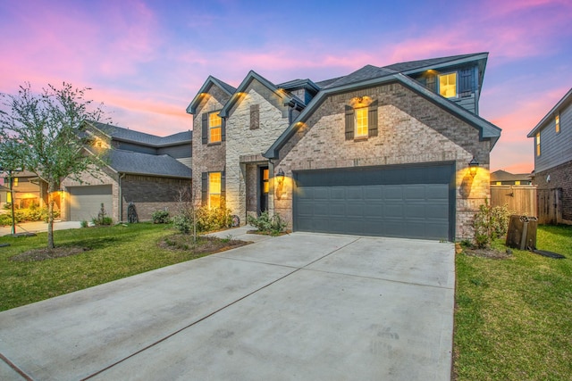 view of front of property with a garage and a lawn