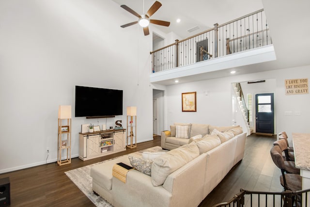 living room featuring a high ceiling, dark hardwood / wood-style flooring, and ceiling fan