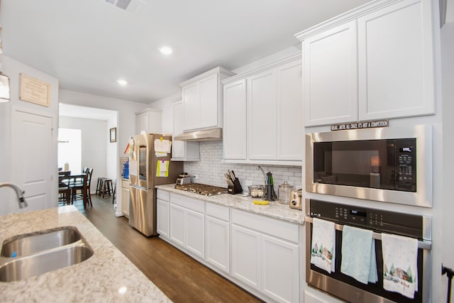 kitchen featuring light stone countertops, white cabinetry, sink, and appliances with stainless steel finishes