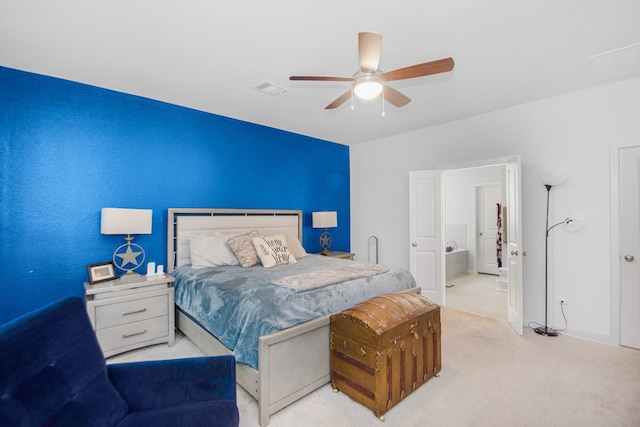 carpeted bedroom with ensuite bath and ceiling fan