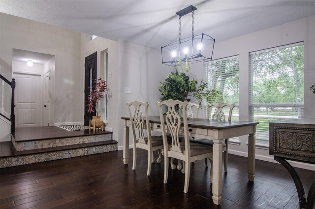 dining area featuring dark wood-type flooring, baseboards, and stairs