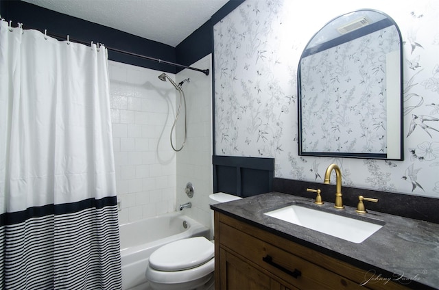 full bathroom featuring wallpapered walls, vanity, toilet, and a textured ceiling