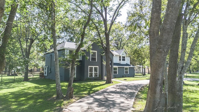 view of front of home with driveway, fence, and a front yard