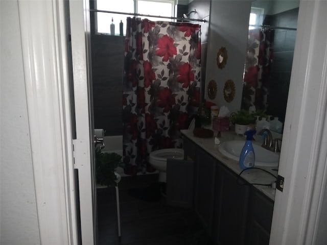 full bathroom featuring toilet, shower / tub combo with curtain, and vanity