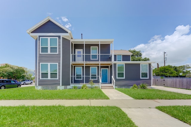 view of front of house with a front lawn and a balcony