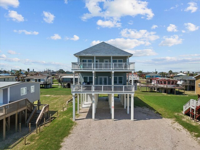 718 Beach Dr, Surfside Beach, TX 77541 - view of front facade featuring a carport, driveway, stairs, and a front lawn