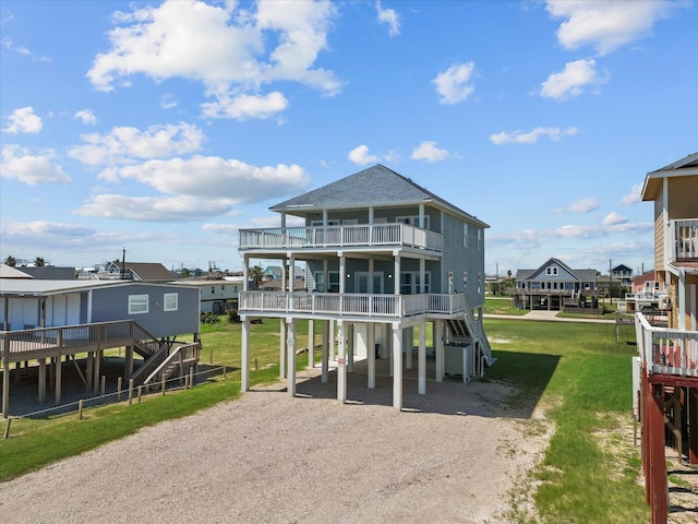 718 Beach Dr, Surfside Beach, TX 77541 - rear view of house featuring stairway, a carport, dirt driveway, a lawn, and a wooden deck