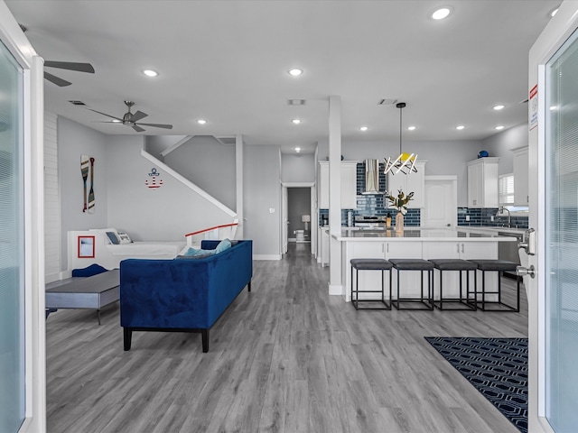 living room with light hardwood / wood-style floors and ceiling fan