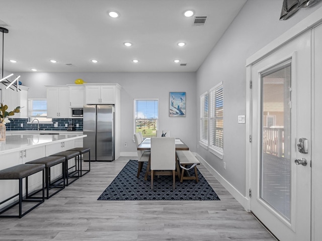 dining space with light wood-style floors, baseboards, visible vents, and recessed lighting