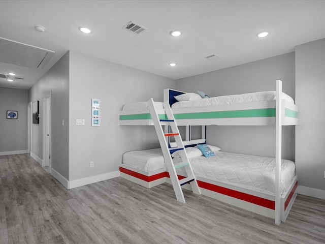 bedroom featuring wood finished floors, attic access, visible vents, recessed lighting, and baseboards