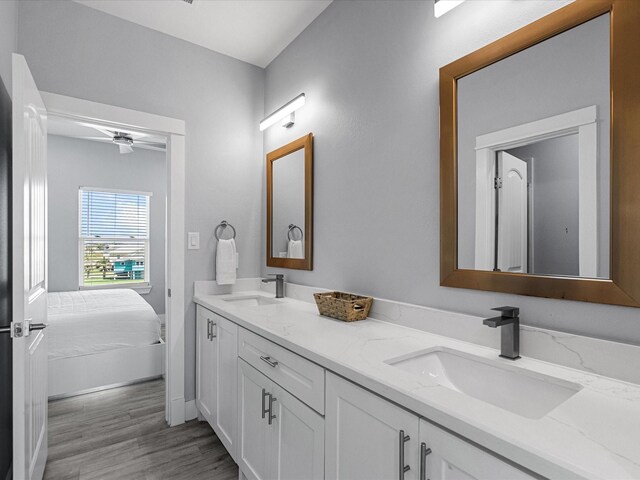 bathroom with ceiling fan, double vanity, a sink, and wood finished floors