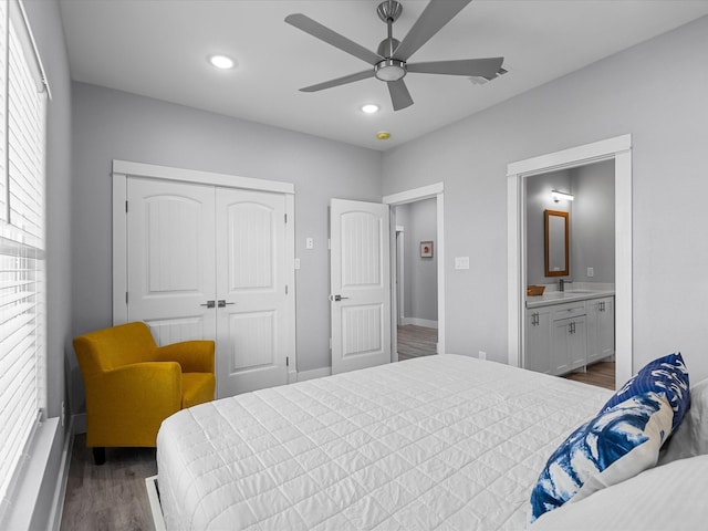 bedroom featuring a sink, a closet, wood finished floors, recessed lighting, and baseboards