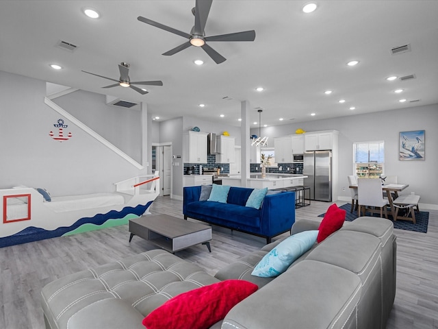 living room featuring light wood finished floors, visible vents, a ceiling fan, and recessed lighting