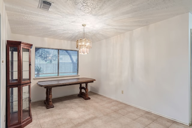 misc room featuring a textured ceiling and a notable chandelier