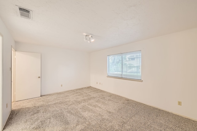 carpeted spare room featuring a textured ceiling