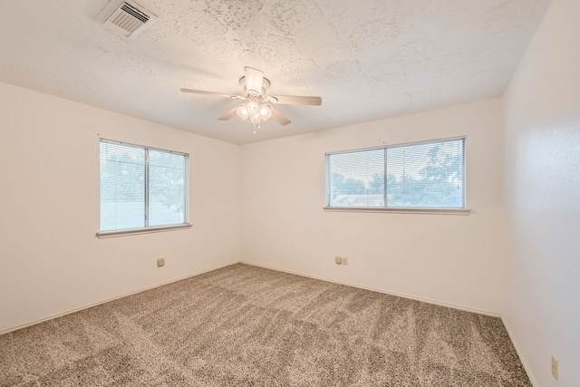 carpeted empty room featuring a textured ceiling and ceiling fan