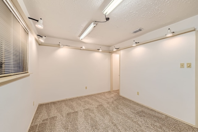 carpeted spare room featuring a textured ceiling