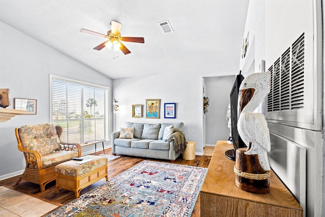 living room with ceiling fan, a textured ceiling, vaulted ceiling, and wood-type flooring