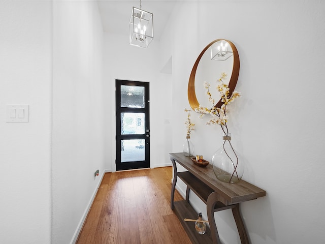 doorway to outside featuring wood-type flooring and a chandelier