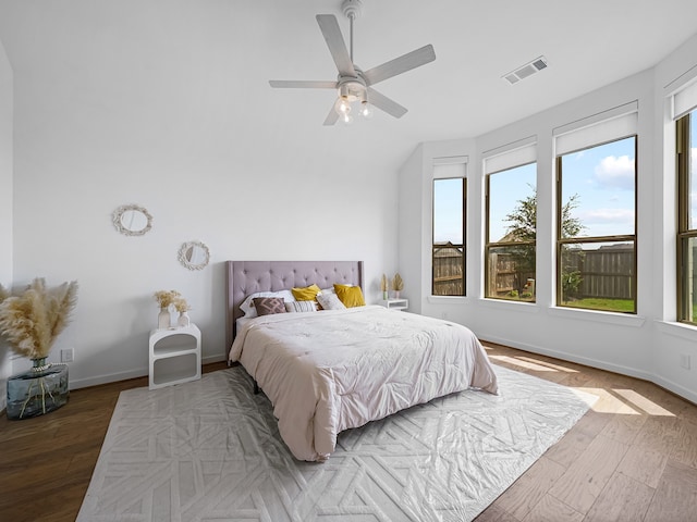 bedroom featuring multiple windows, ceiling fan, and dark hardwood / wood-style floors