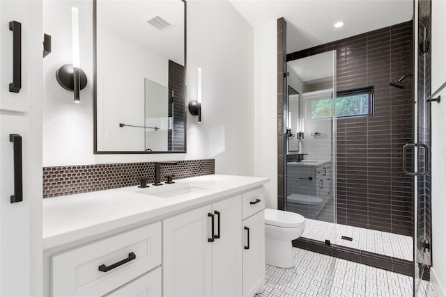 bathroom featuring decorative backsplash, vanity, a shower with door, tile patterned flooring, and toilet