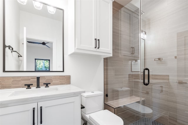 bathroom featuring tasteful backsplash, toilet, vanity, and walk in shower