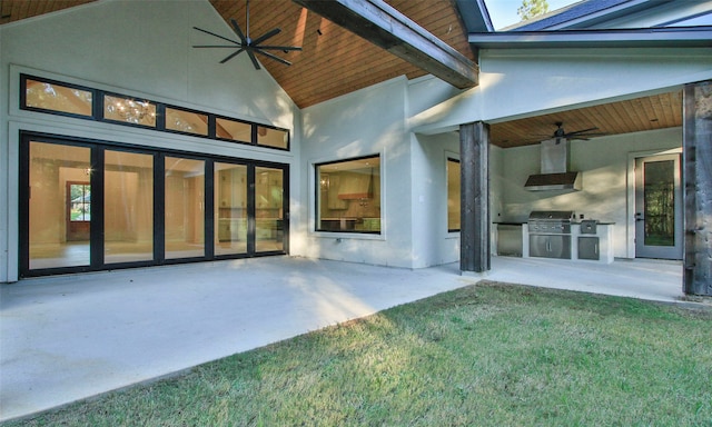 rear view of house featuring area for grilling, ceiling fan, a patio area, and a lawn