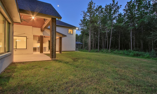 yard at dusk featuring a patio area