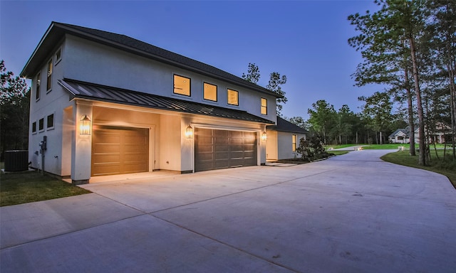 view of front of house with central air condition unit and a garage