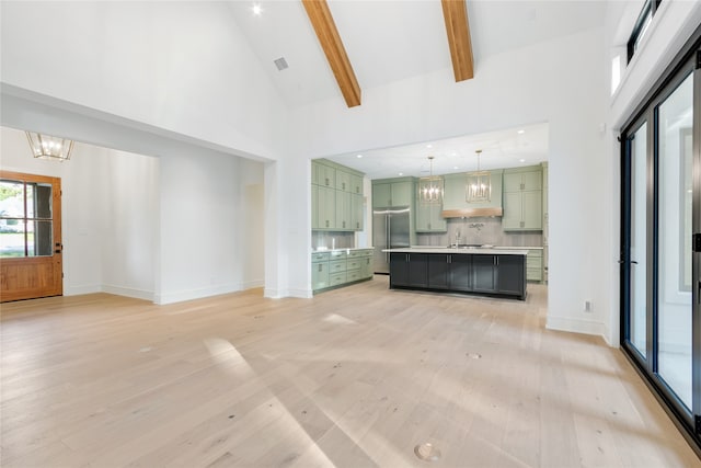 unfurnished living room with beam ceiling, light hardwood / wood-style floors, high vaulted ceiling, and a notable chandelier