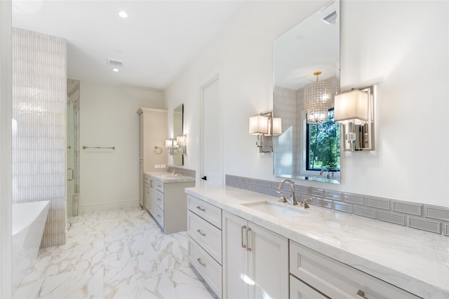 bathroom with vanity, independent shower and bath, and a notable chandelier