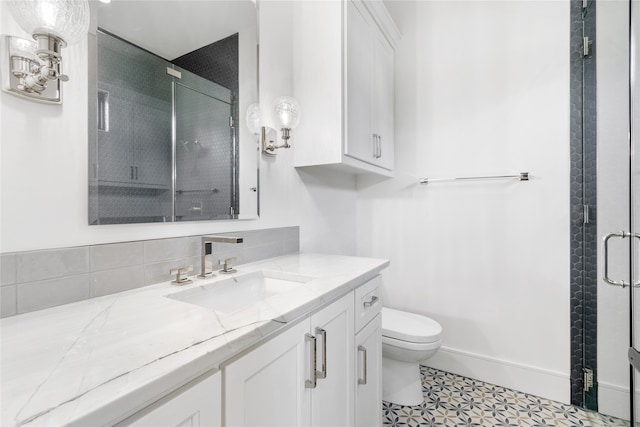 bathroom with tile patterned floors, toilet, decorative backsplash, vanity, and a shower with shower door