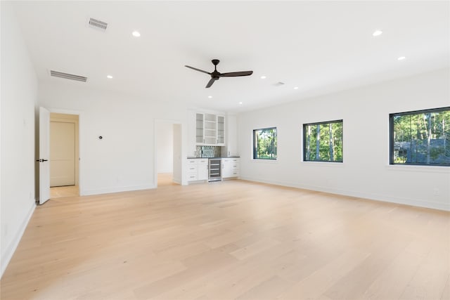 unfurnished living room featuring light hardwood / wood-style flooring, beverage cooler, and ceiling fan